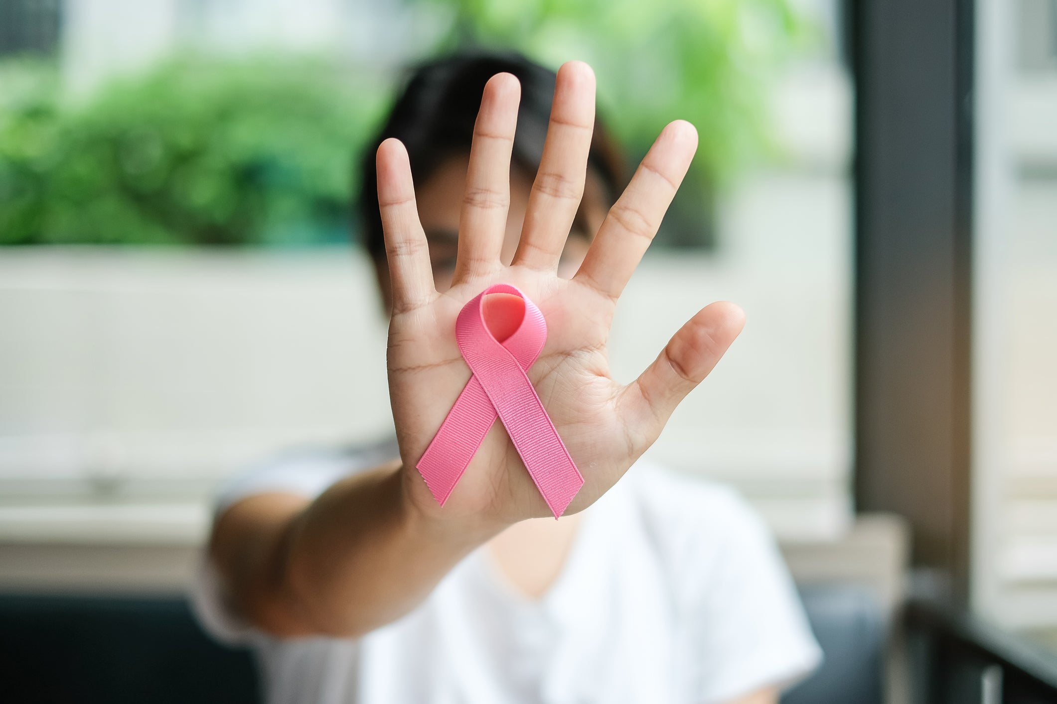 Close-Up Of Woman Hand Showing Breast Cancer Awareness Ribbon