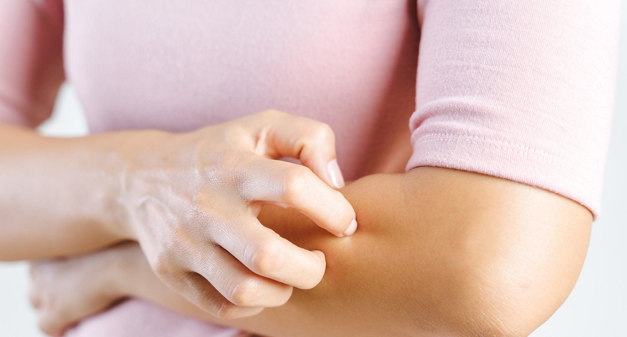Midsection Of Woman Scratching Hand Against White Background