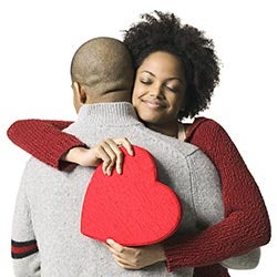 couple hugging and holding a red heart