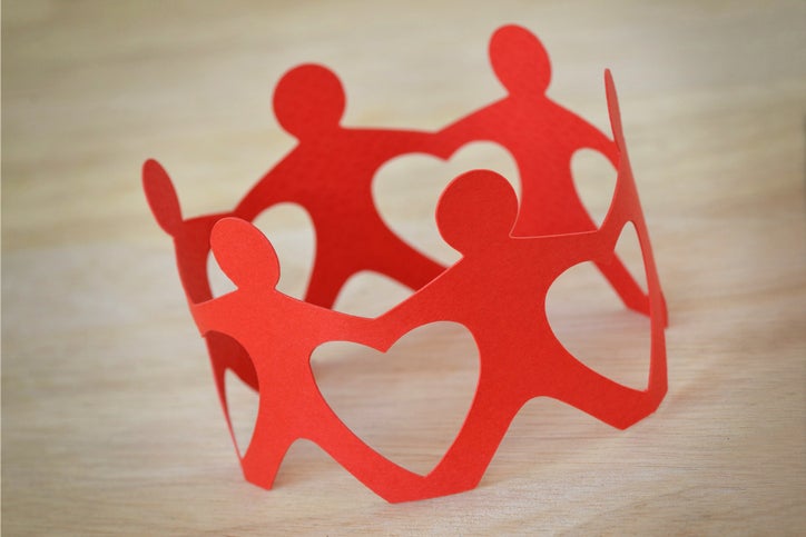 Paper cutout of people holding hands