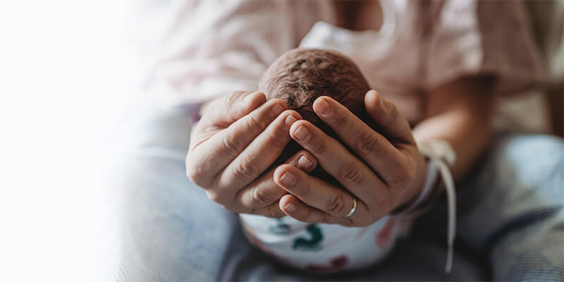 mom holding newborn baby's head