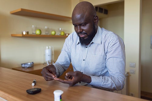 man checking blood sugar