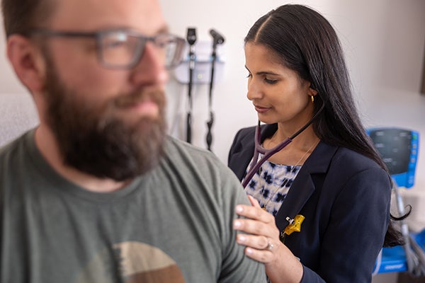 doctor checking patient lungs