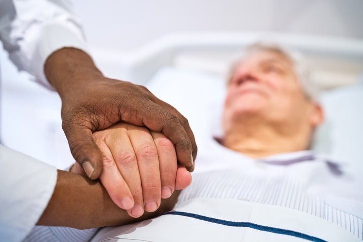 doctor holding hand of sick patient