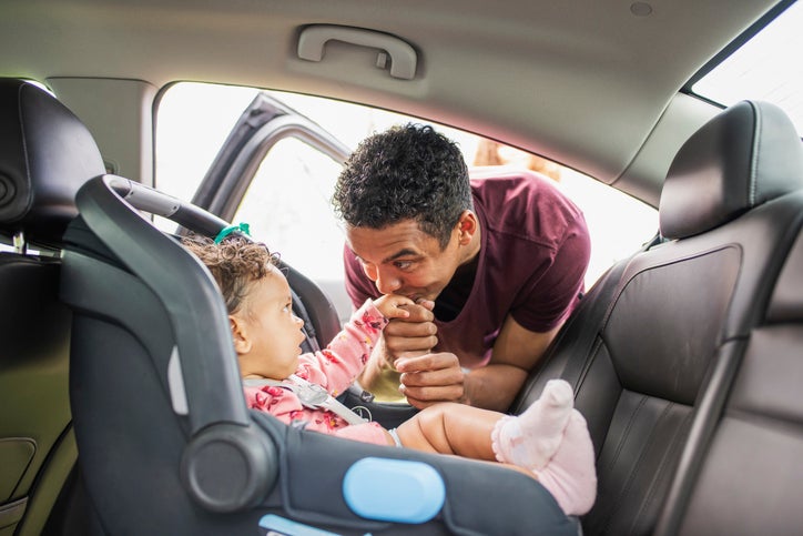 dad kissing baby in car seat