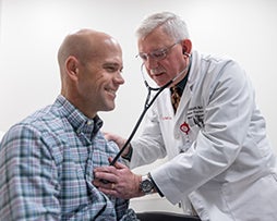 Dr. checking patient's heart beat