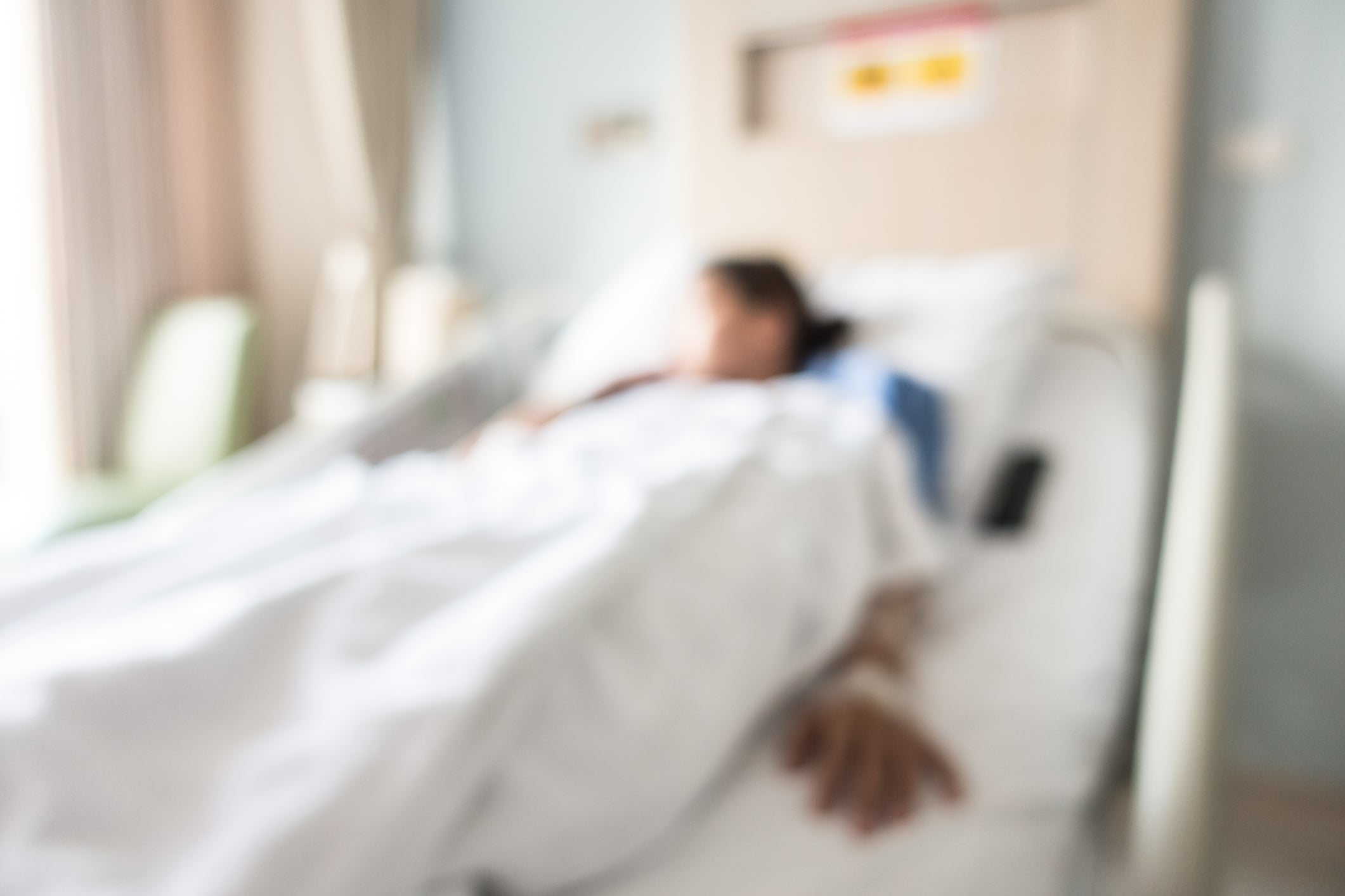 Defocused image of patient lying down the bed in hospital
