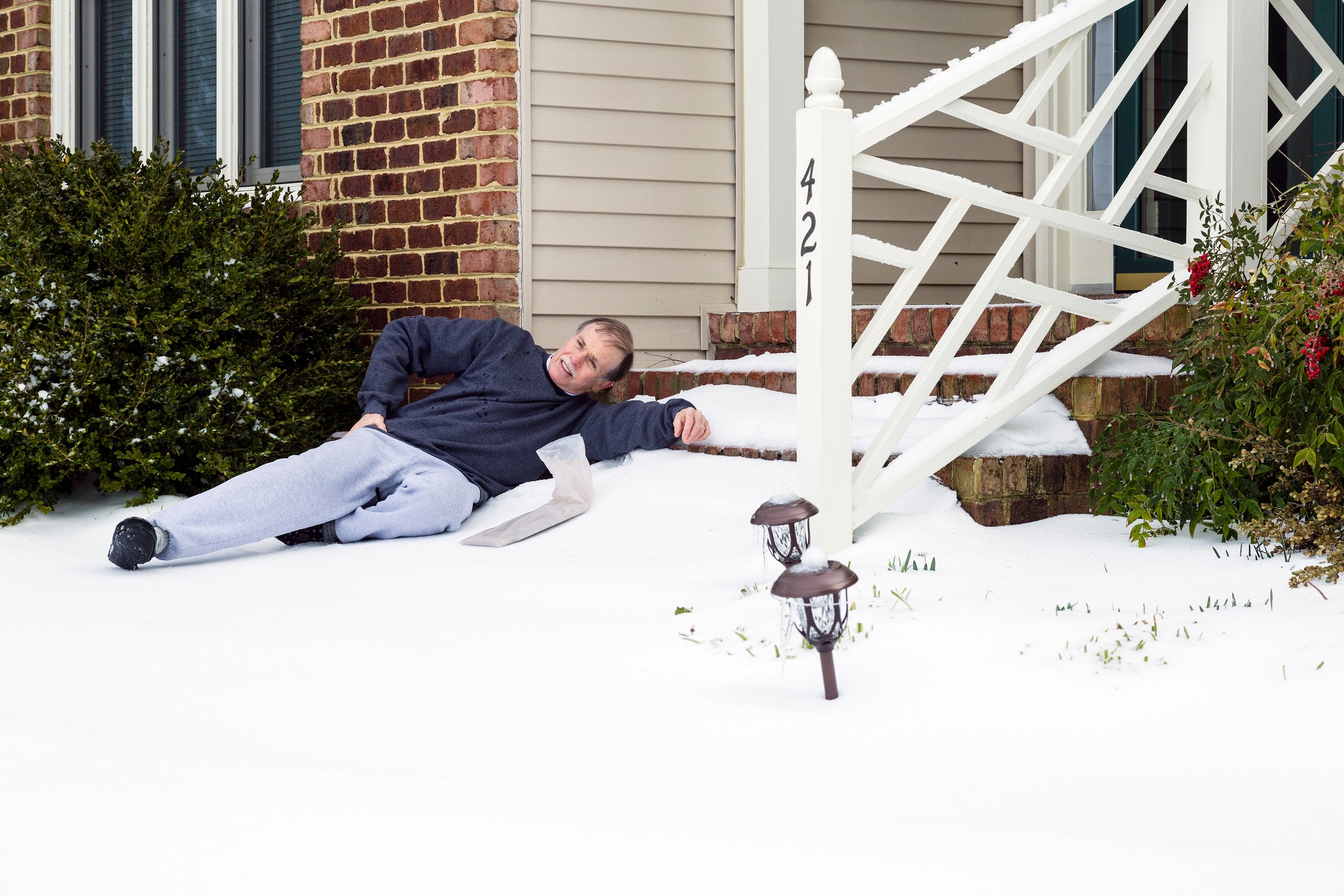 Senior adult male grimaces in pain in the snow.