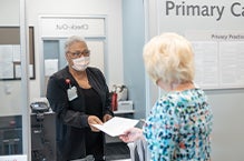 Primary Care Medical Staff Assisting a Patient at the Front Desk
