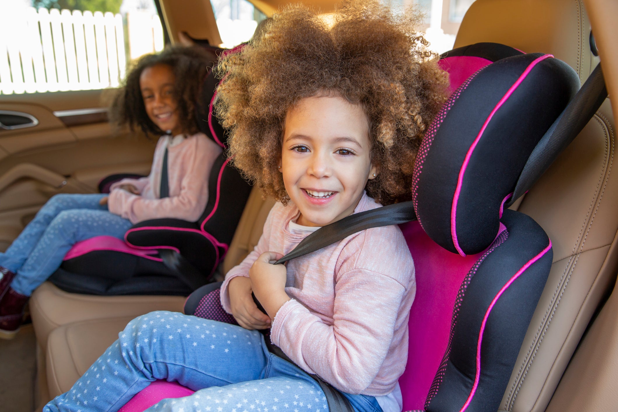 Ethnic sister girls car back seat with belts