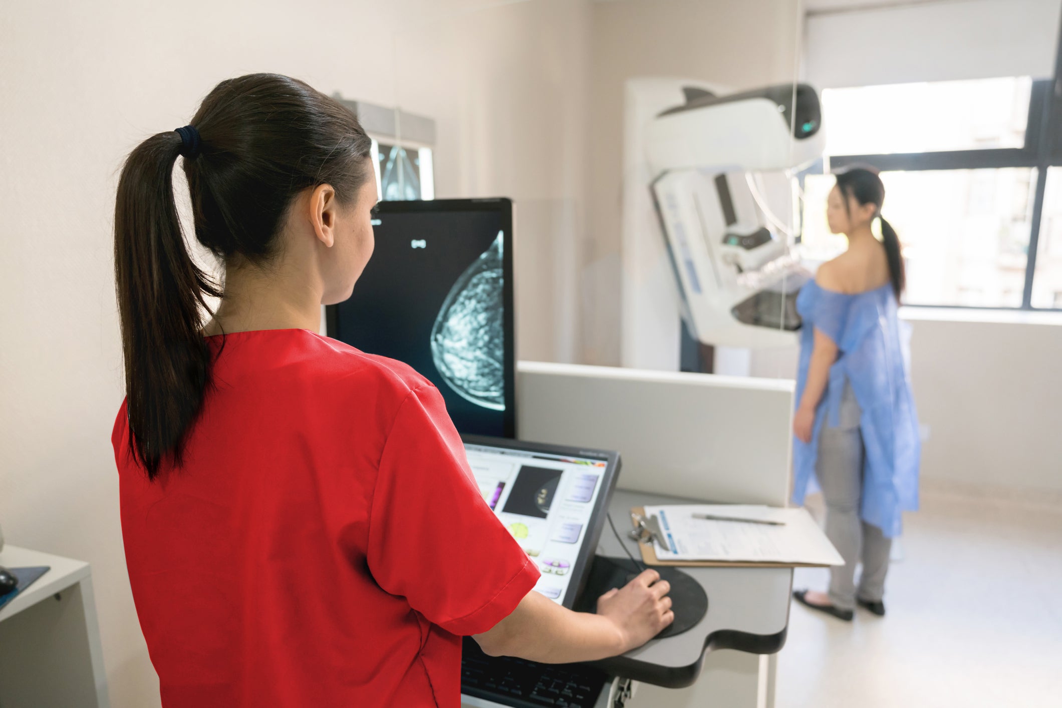 Unrecognizable nurse taking a mammogram exam to an adult patient