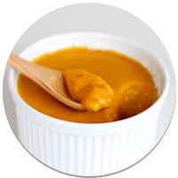 wood spoon scooping a bowl of pumpkin pudding