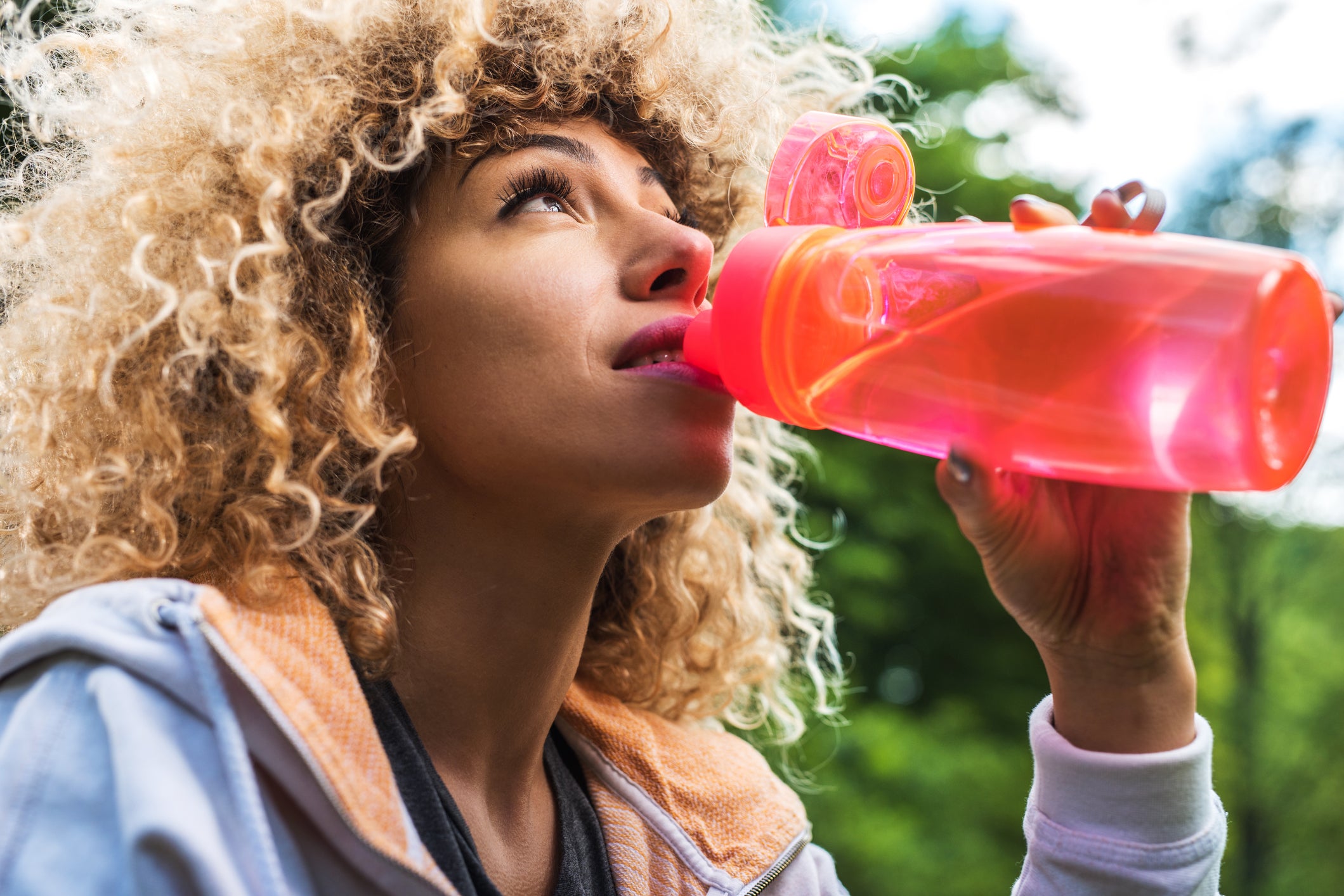 Athletic African American woman drinking water on a break.