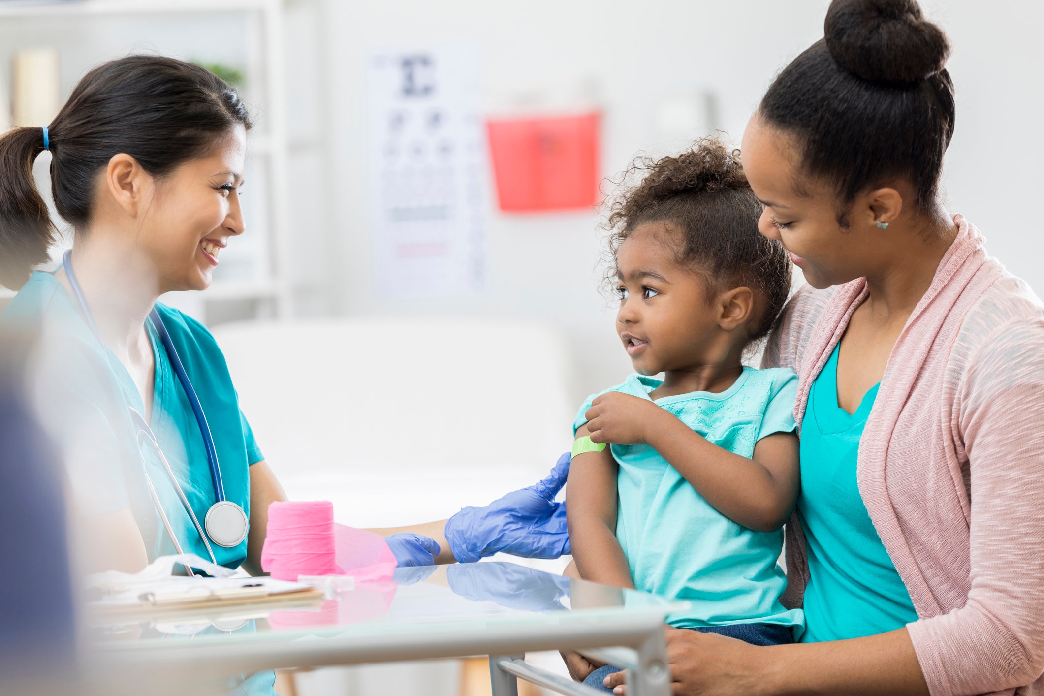 Pediatric nurse puts bandage on young patient&rsquo;s arm