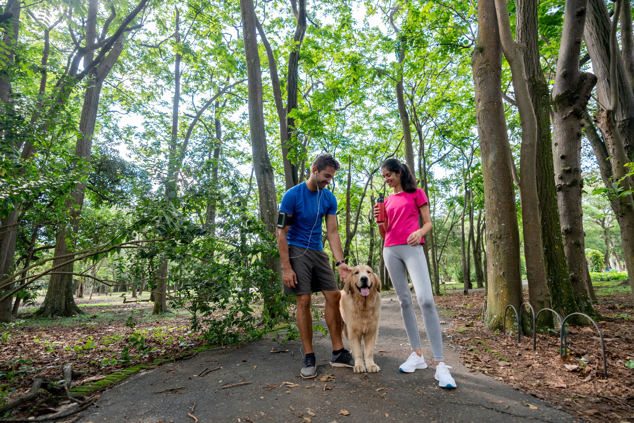 Happy couple running outdoors with their dog