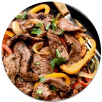 steak fajitas in a cast iron pan