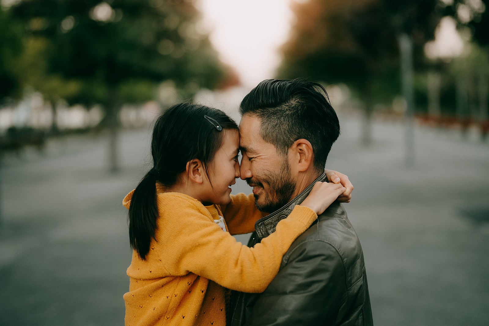 Japanese father and young daughter hugging at dusk
