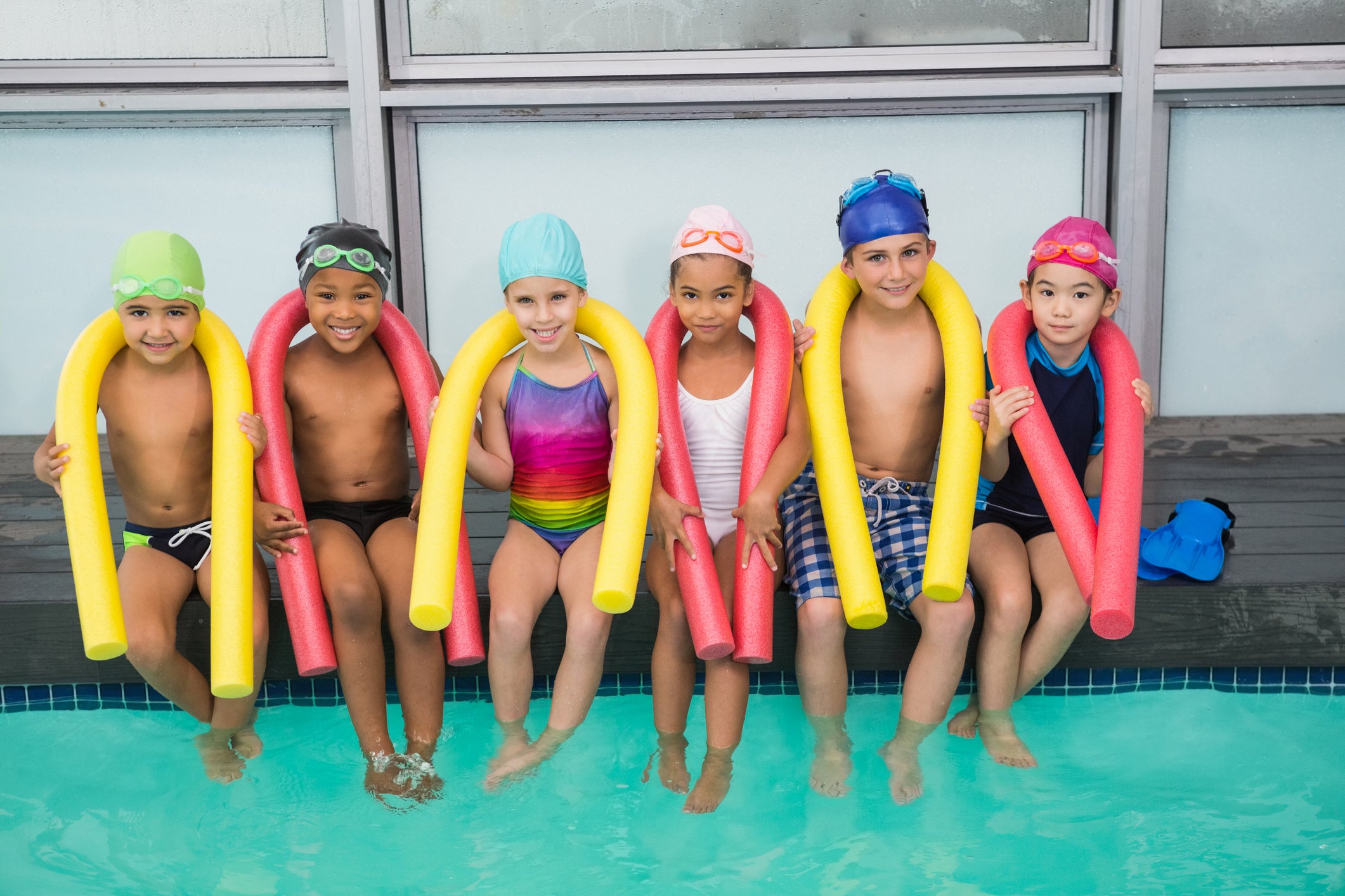 Cute swimming class smiling poolside