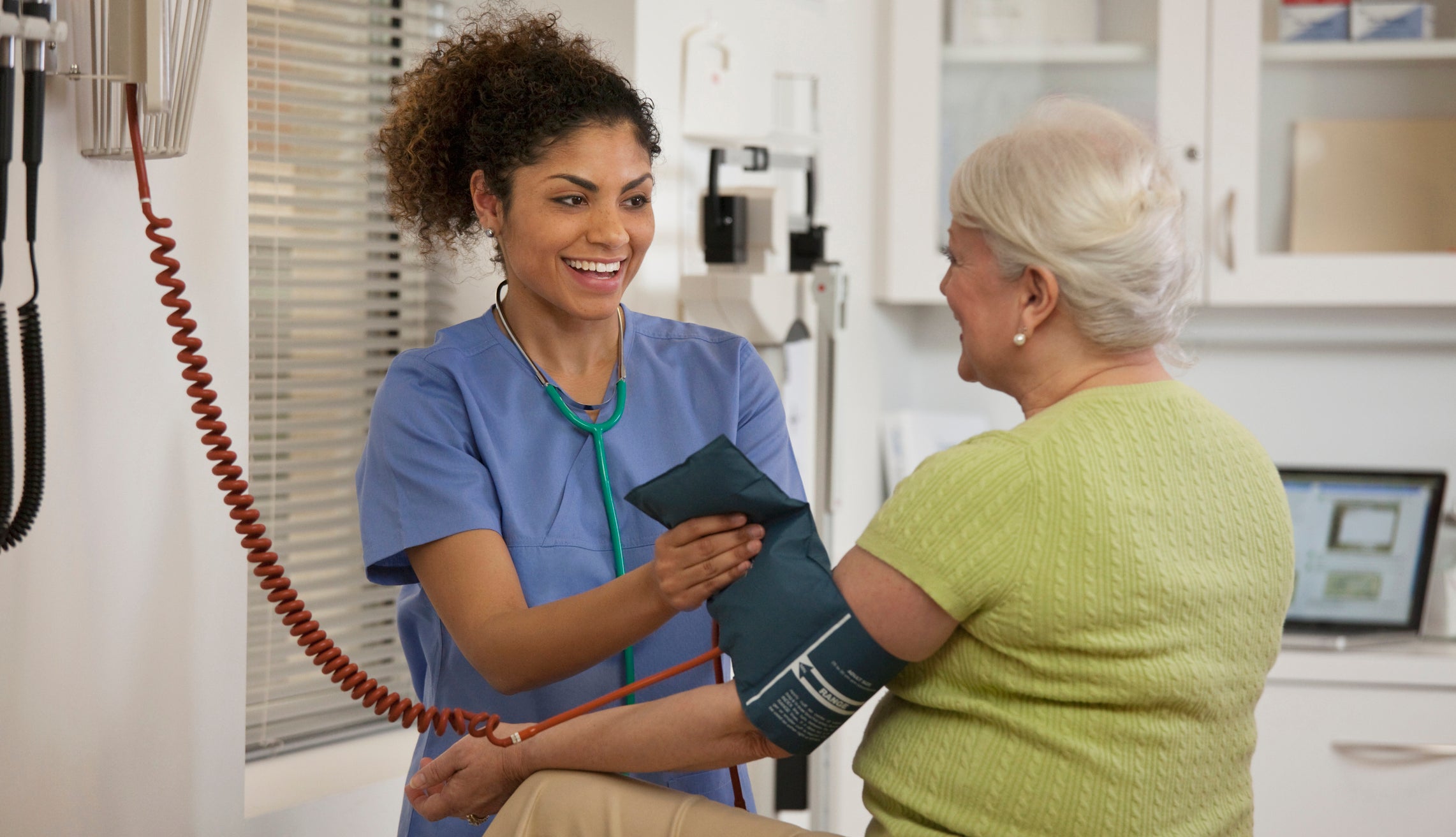 Nurse taking woman&rsquo;s blood pressure