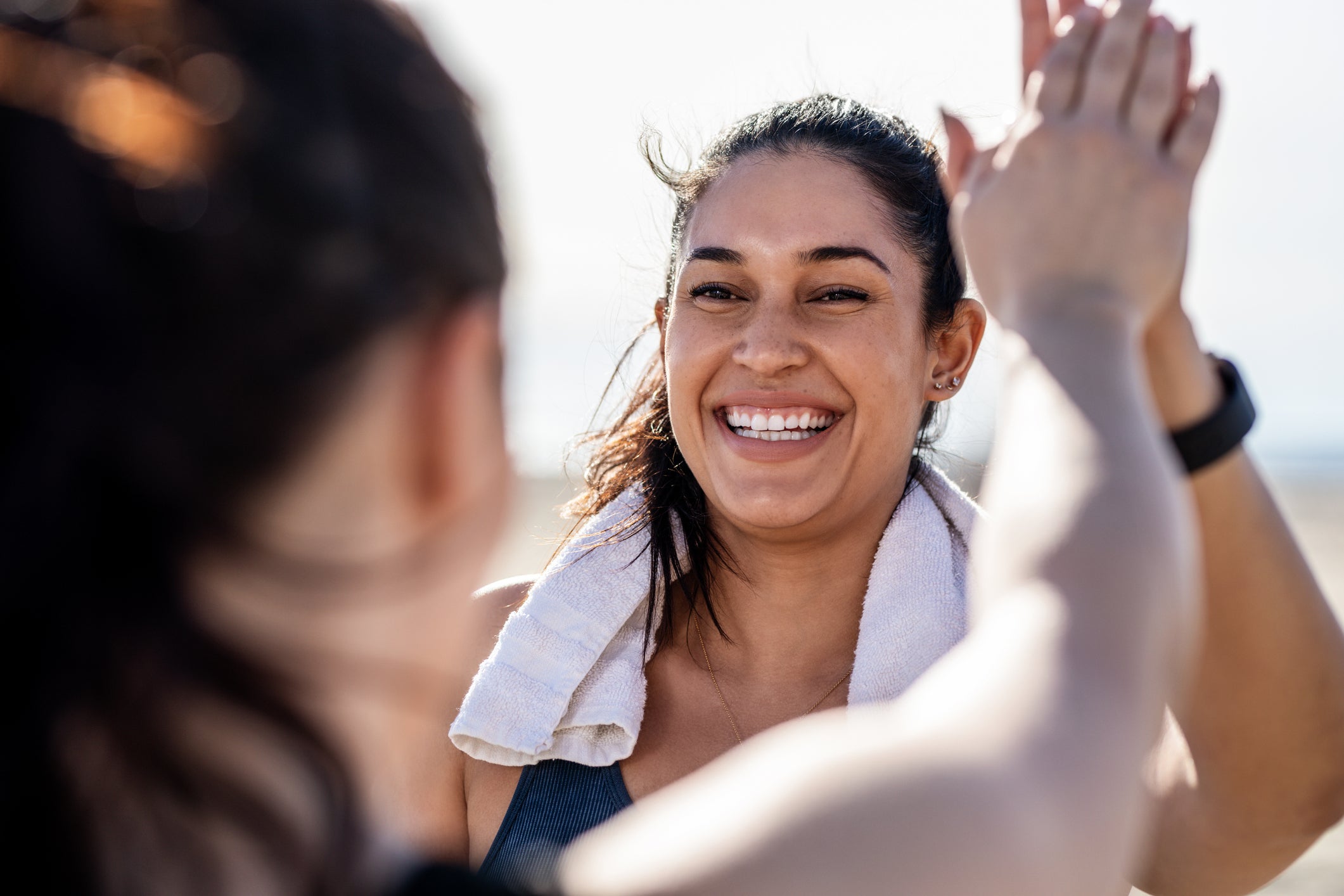 Smiling woman giving high five to her friend after exercising