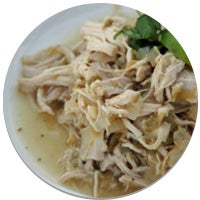 chicken verde on top of rice on a plate with a spoon