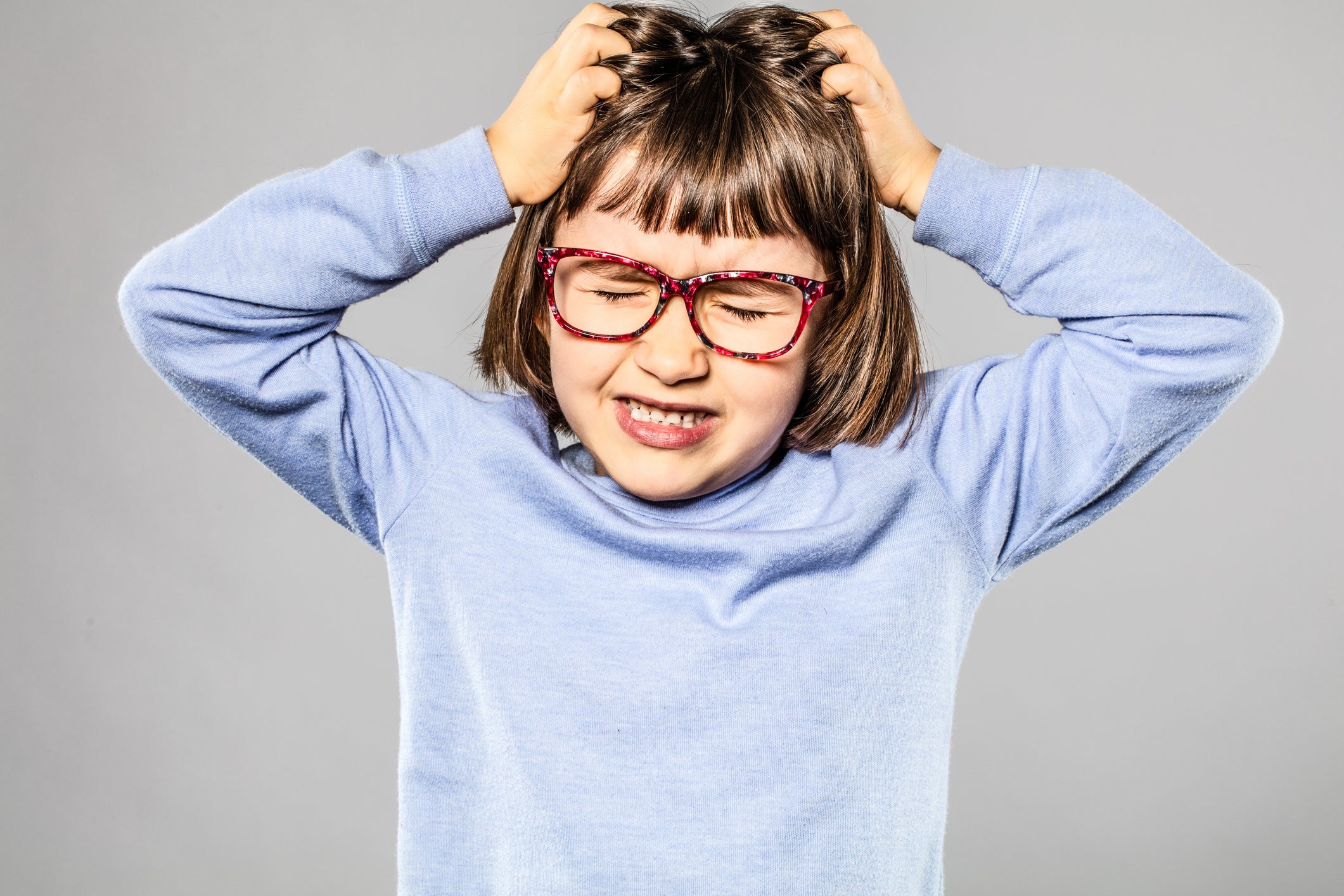 irritated young girl pulling out hair for itchy lice allergies