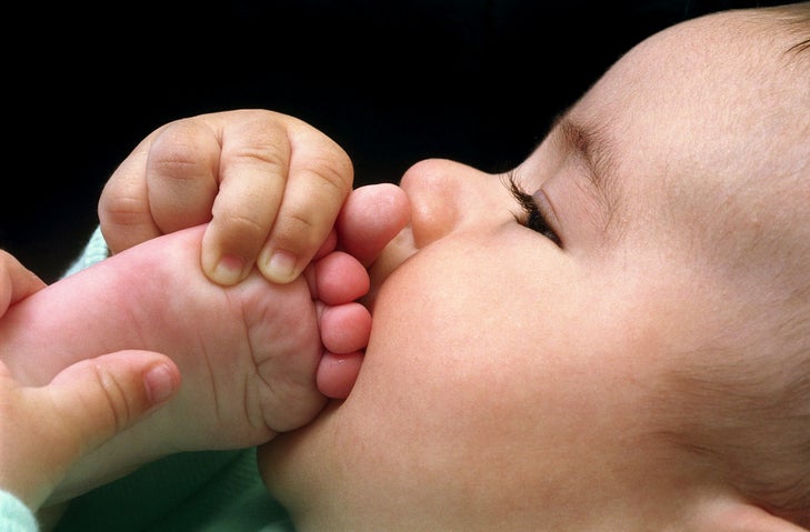 Baby biting his own foot.