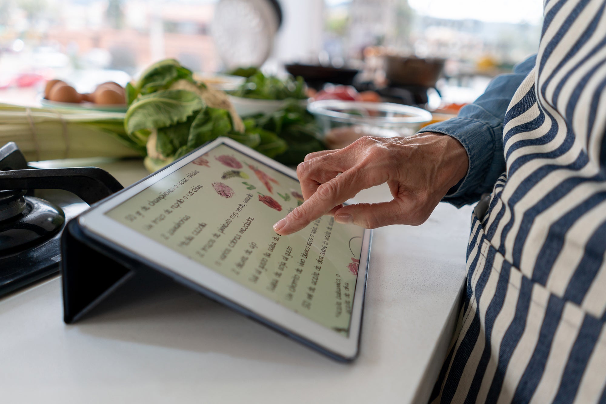Close-up on a woman following a recipe online while cooking at home