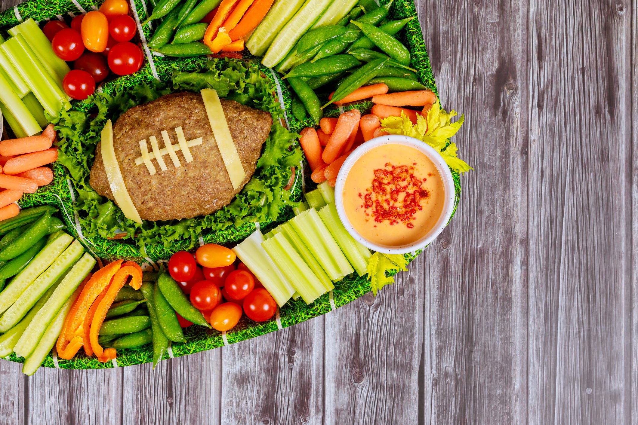 Football meatloaf with vegetable and dipping for Super Bowl fan party.
