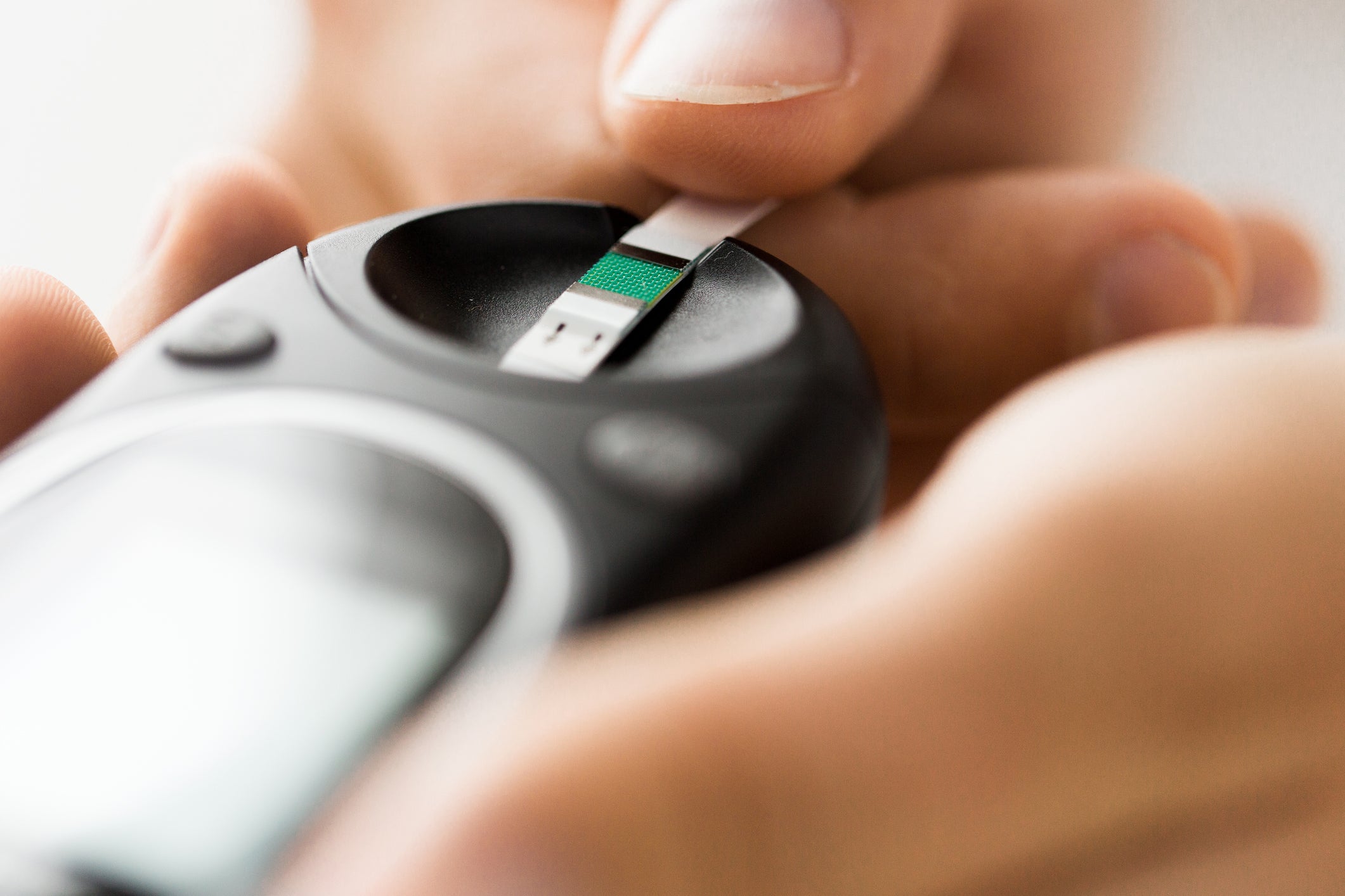 close up of man checking blood sugar by glucometer