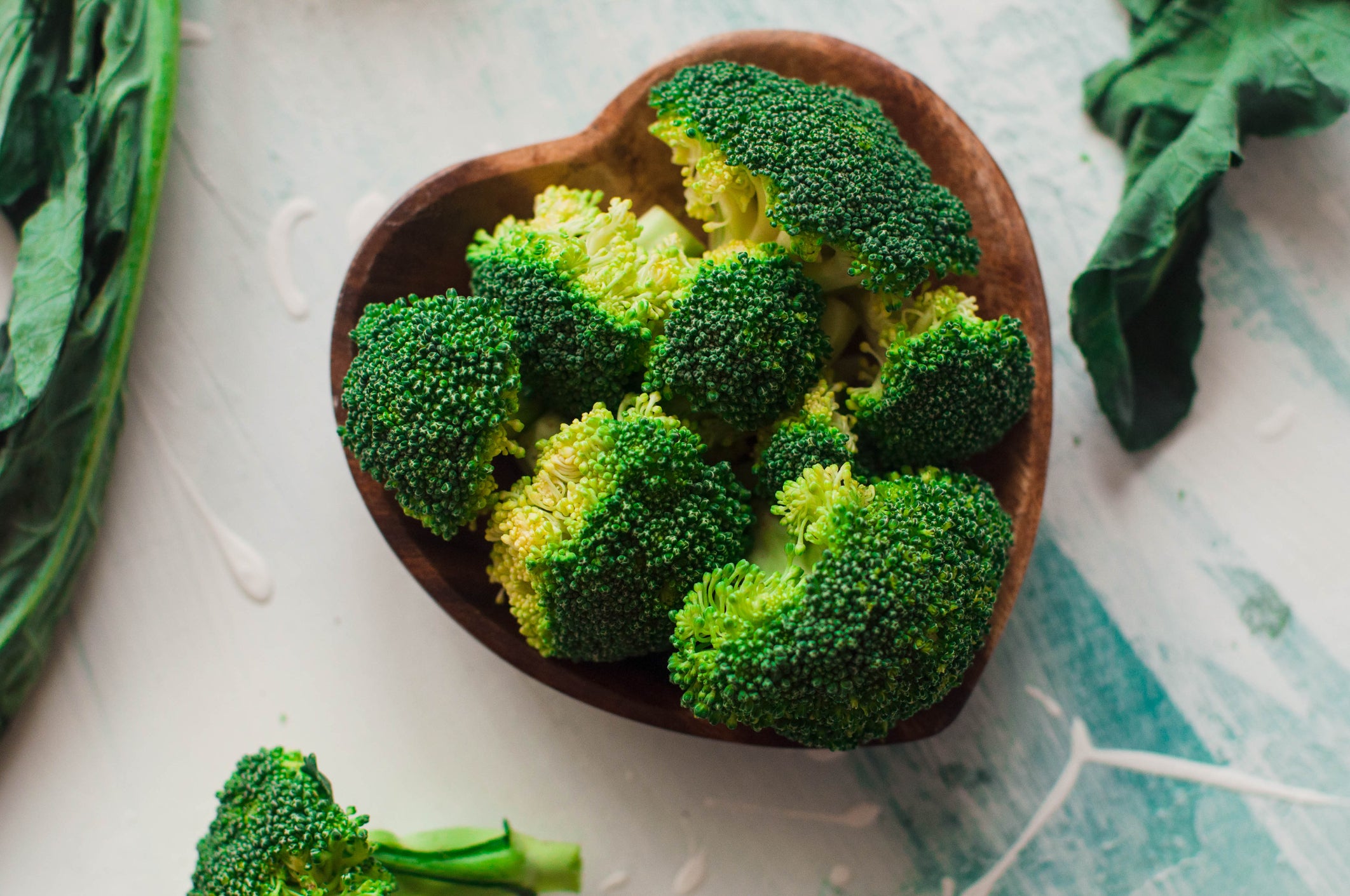 Chopped broccoli on a wooden heart-shaped bowl