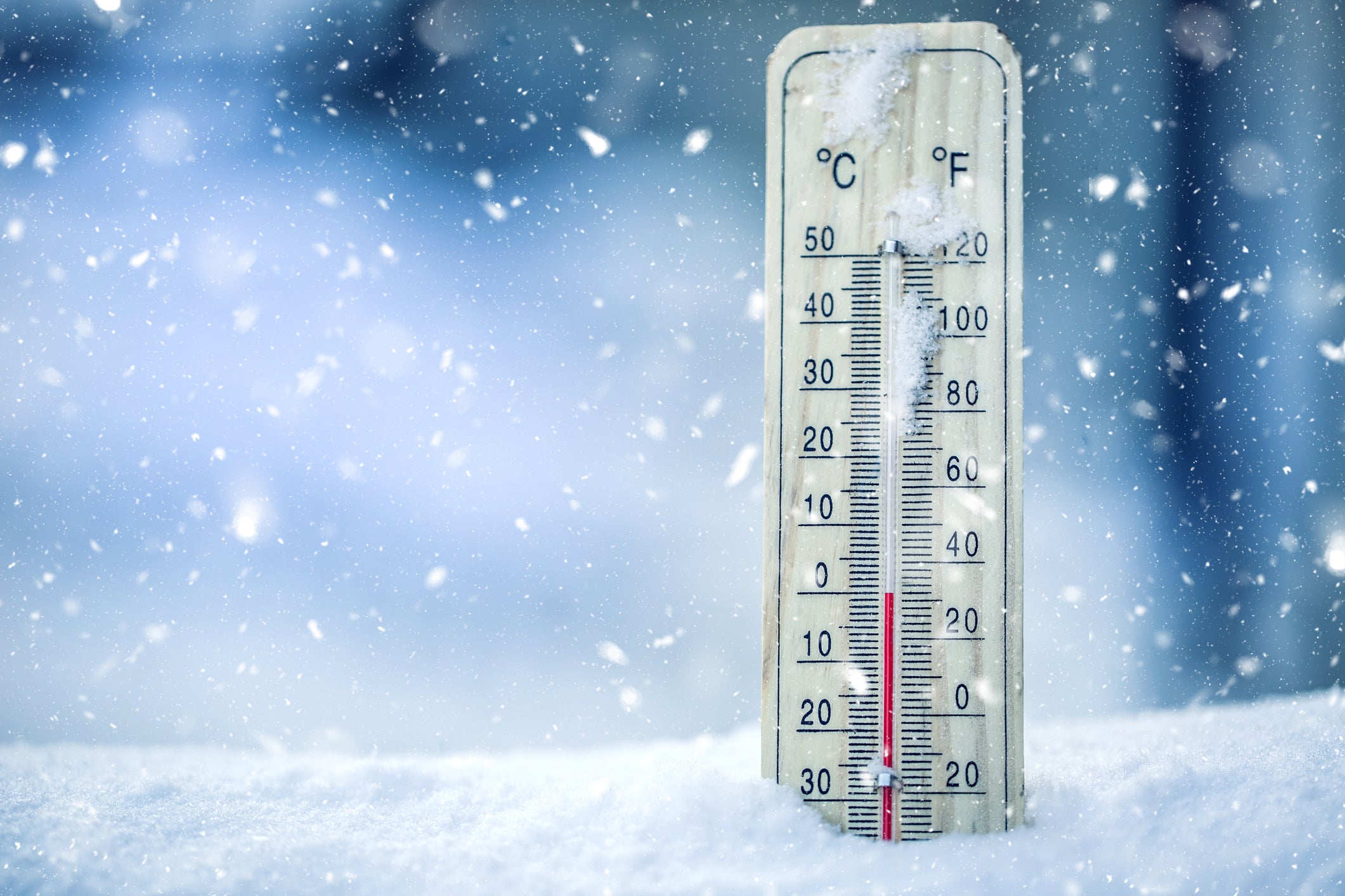 Thermometer on snow shows low temperatures &ndash; zero. Low temperatures in degrees Celsius and fahrenheit. Cold winter weather &ndash; zero celsius thirty two farenheit