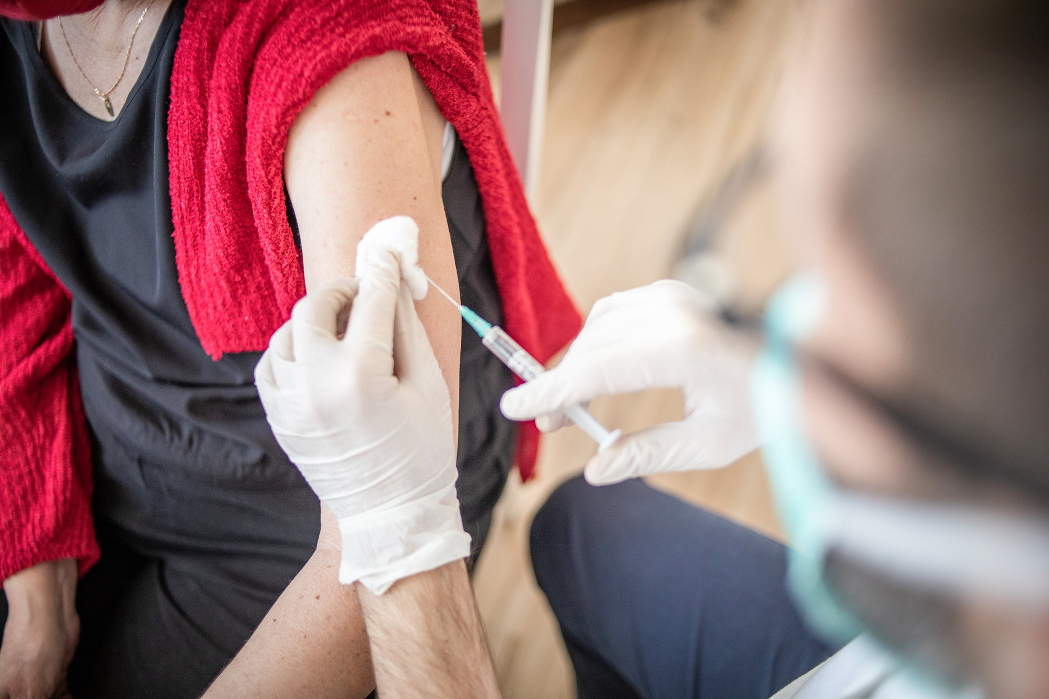 Booster dose vaccine Covid 19. The doctor gives the vaccine to an older woman.