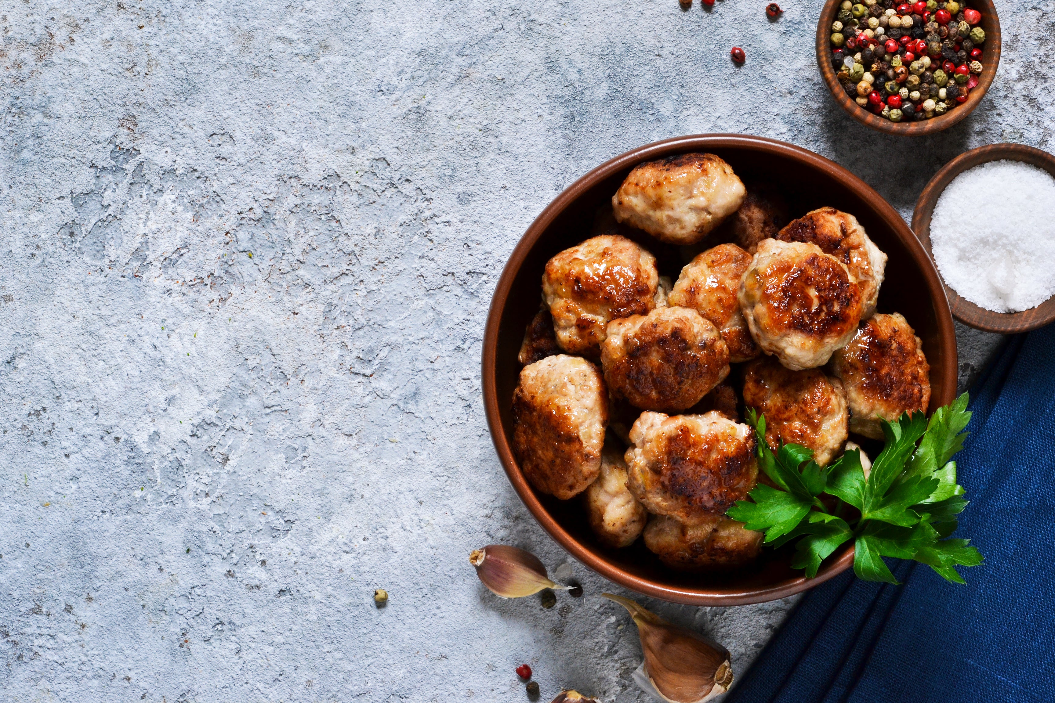 Meat balls with spices on a concrete background. View from above.