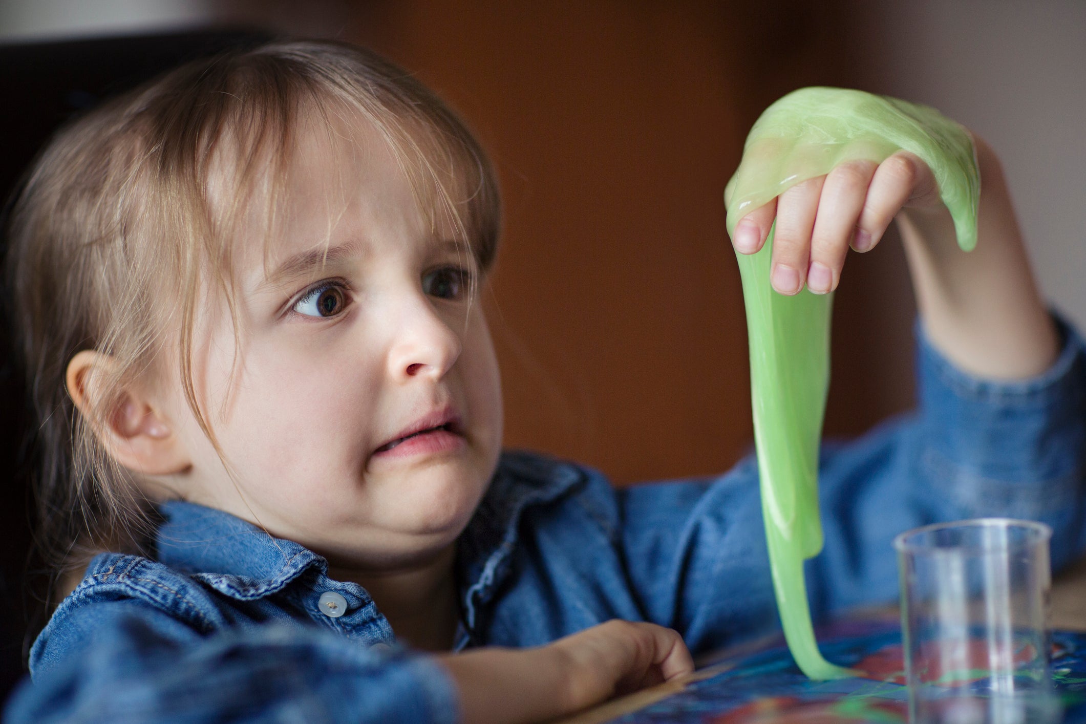 Child (6-7) looking at novelty green slime in disgust