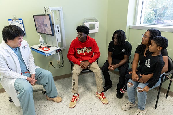 Dr.  Ho in patient room with Stinsons