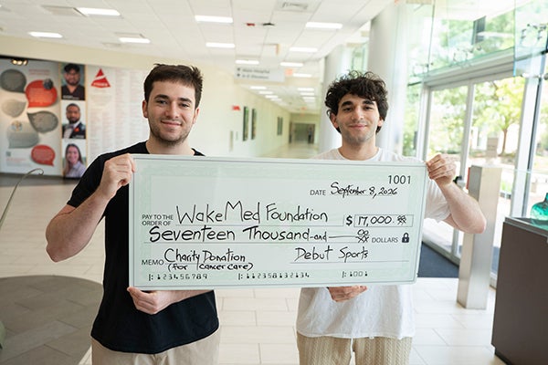 brothers holding the check