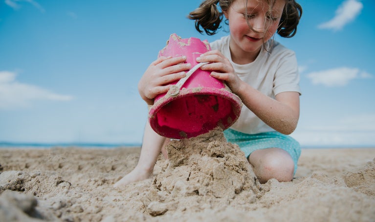 child digging in sand