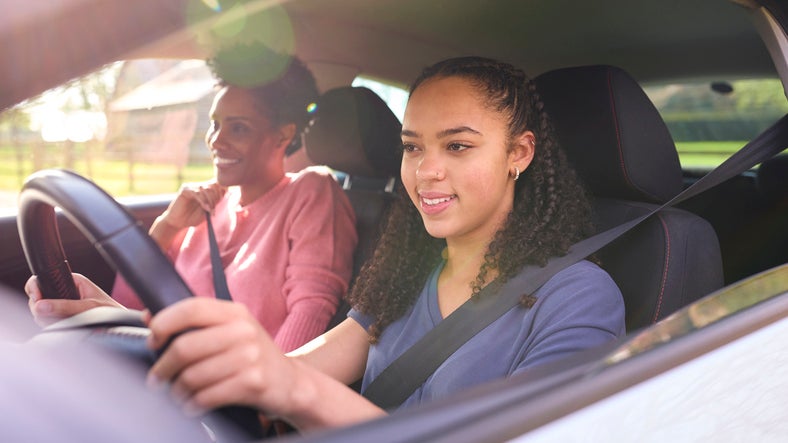 teen driving with mom in passenger seat