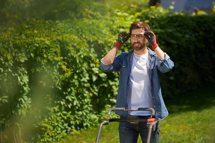 dad mowing lawn with safety goggles