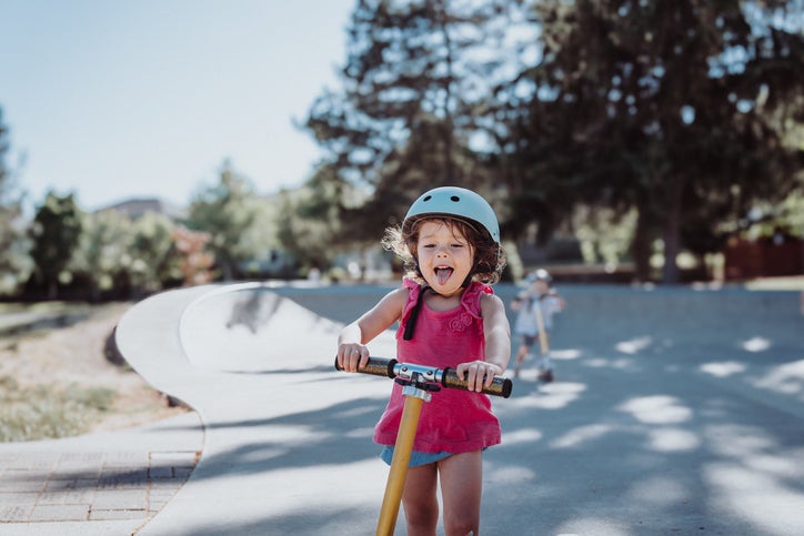 child on scooter with helmet