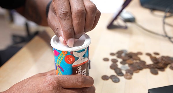 JT putting pennies in a can