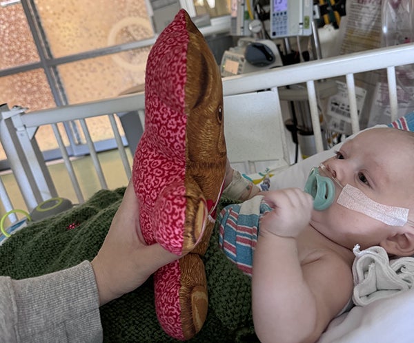 baby entertained by stuffed toy
