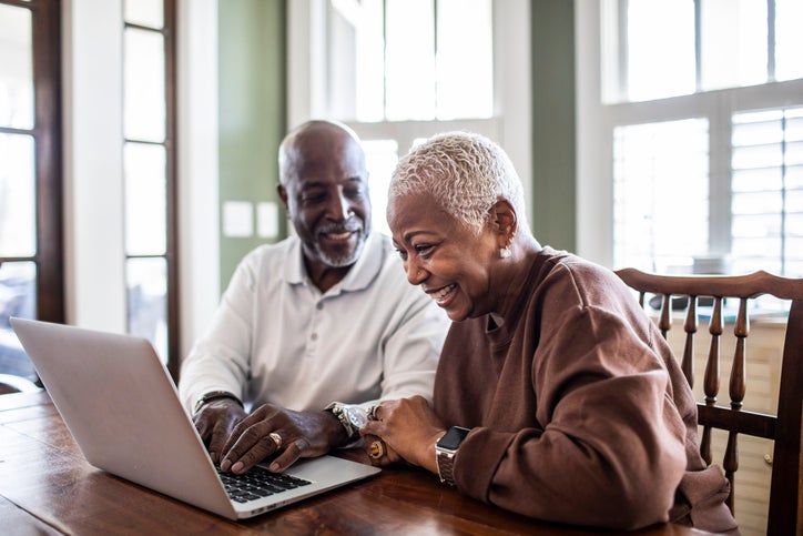 older couple at the kitchen table with a laptop